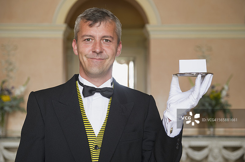 手持名片在托盘上的白人管家图片素材