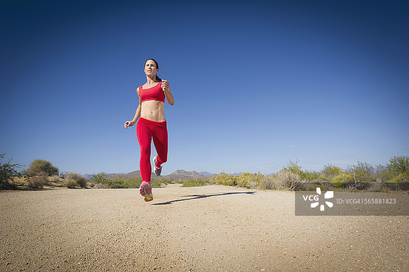 白人女性在偏僻的土路上跑步图片素材