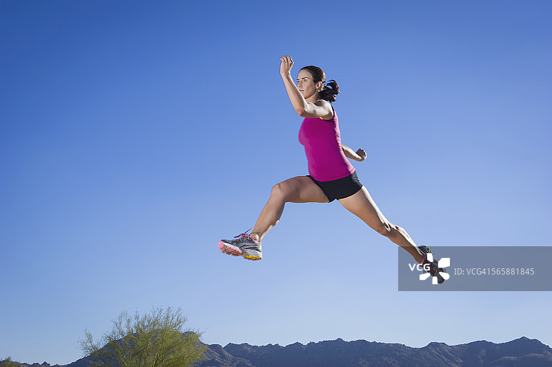 蓝天下跳跃的白人跑步者图片素材