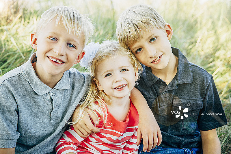 在草地上微笑的白人兄弟姐妹图片素材