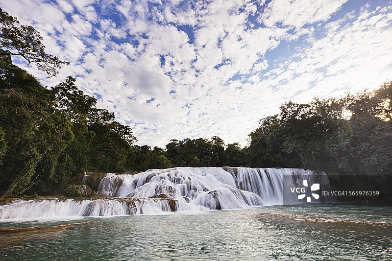 河中岩石上瀑布的低角度视角图片素材