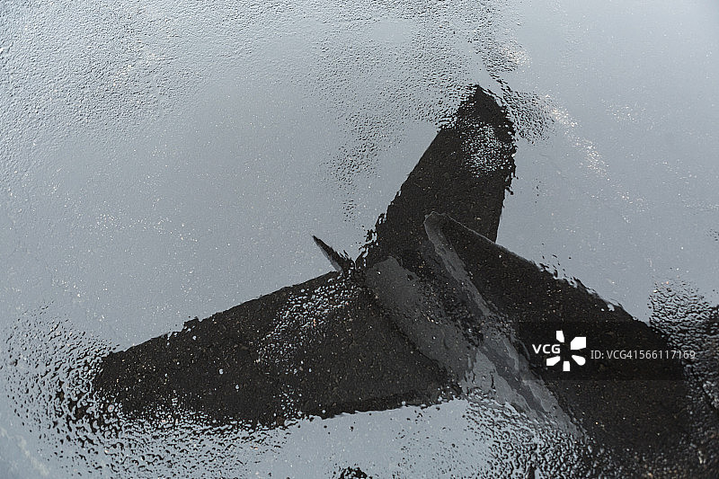 私人飞机尾部在水坑中的倒影图片素材