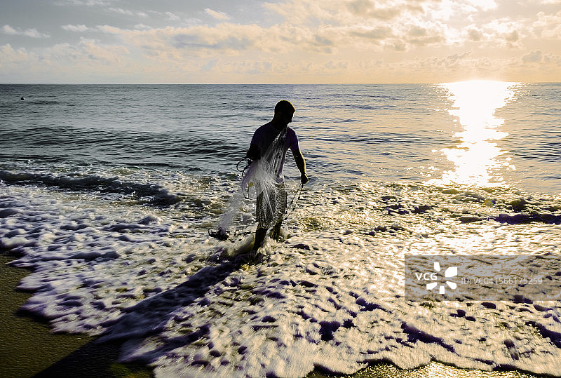 维罗海滩：男人在海中撒网捕鱼图片素材