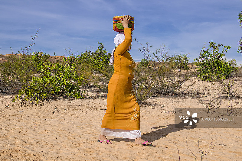 占族妇女 carrying 彩色篮子图片素材