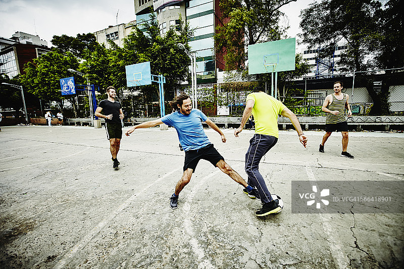 城市公园里争抢足球的运动员图片素材