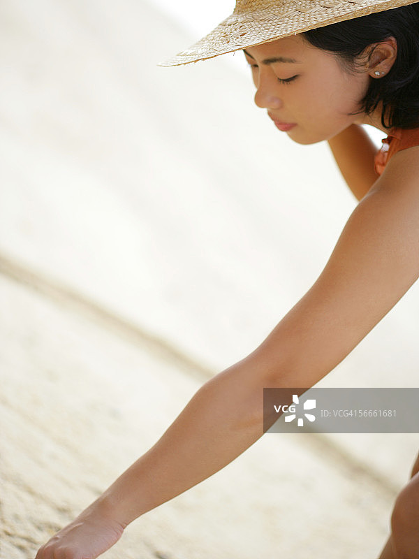 年轻女子在海滩上绘画的侧面轮廓图片素材