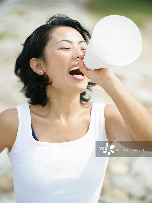 年轻女人对着扩音器喊叫的高角度视图图片素材