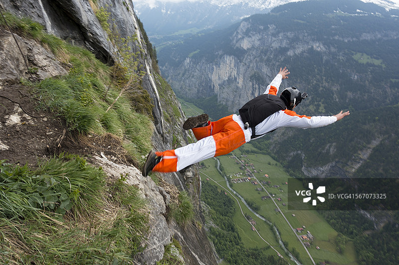 跳伞者从悬崖跳入山谷图片素材