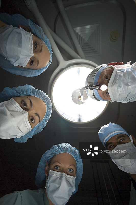 五位外科医生站在手术台上的仰视角度图片素材