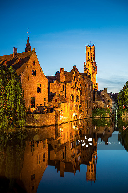 黄昏时钟楼和房屋在运河中的倒影图片素材