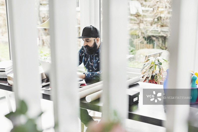 男建筑师在家里的办公室的桌子旁工作图片素材