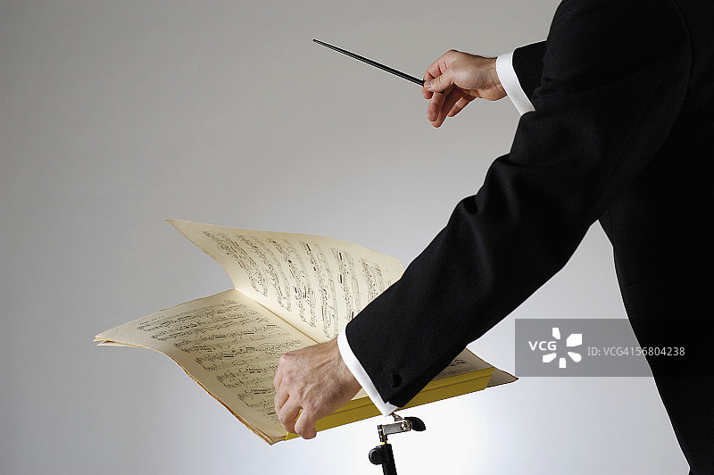 指挥家拿着指挥棒的腰部特写图片素材