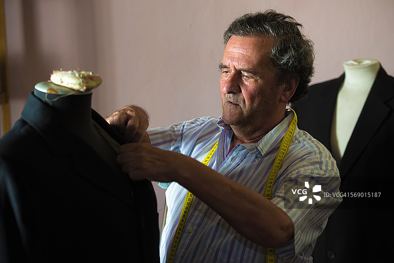 在裁缝店缝纫的老年男人图片素材