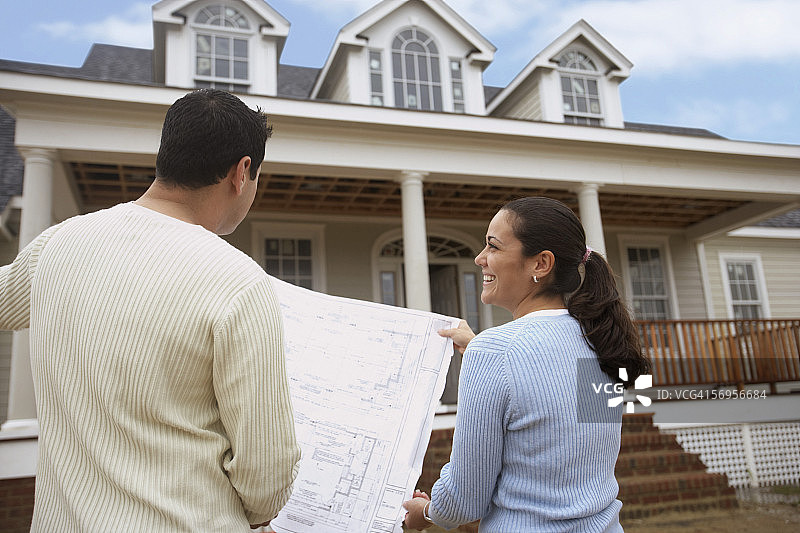 情侣在屋外看房屋设计图的背影图片素材