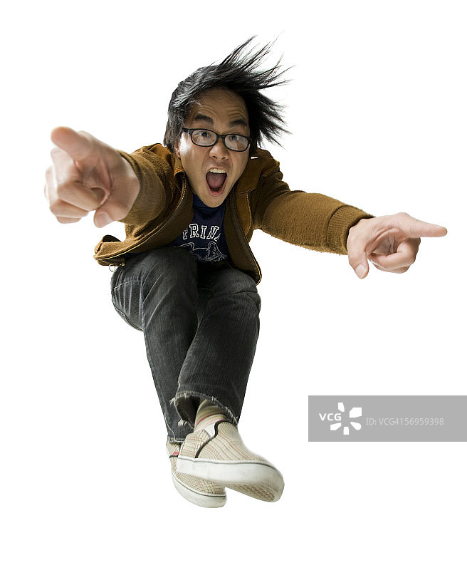 跳跃并指向的年轻男人肖像图片素材