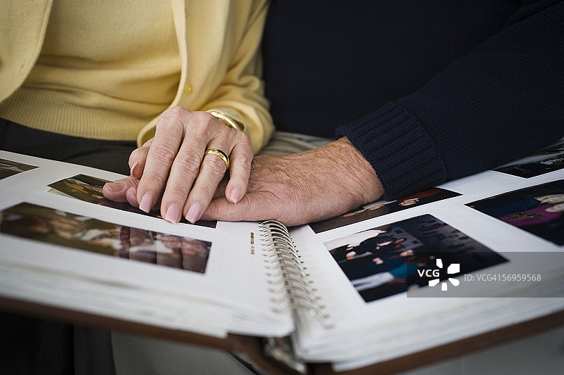 一对夫妇正在看相册的身体中部视角图片素材