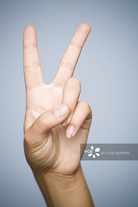 人物手势和平符号特写；表示和平的符号语言和数字二图片素材
