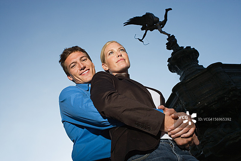 厄洛斯雕像旁情侣相拥图片素材