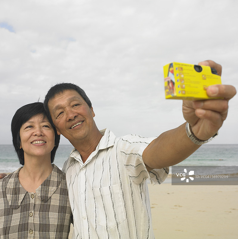 夫妻在海滩拍照图片素材