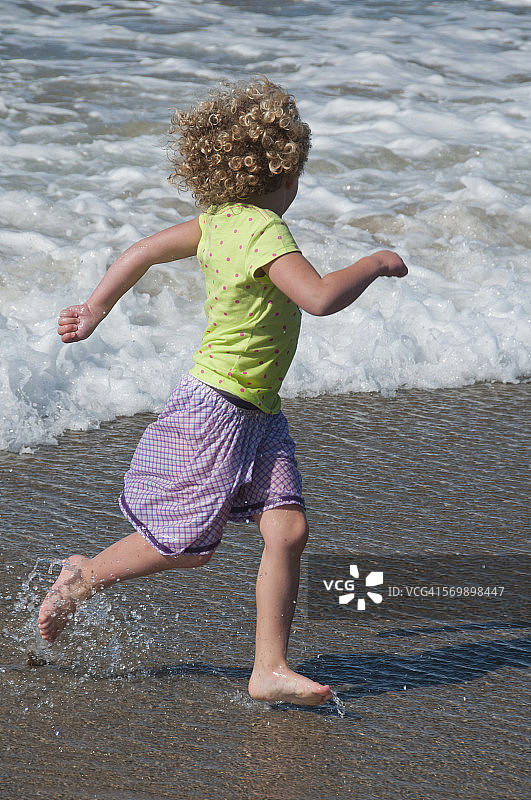 6岁女孩在俄勒冈海岸冲浪图片素材