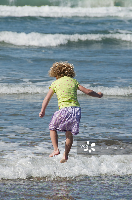6岁女孩在俄勒冈海岸冲浪图片素材