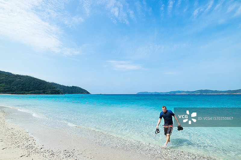 在热带海滩上带着浮潜装备的男人图片素材
