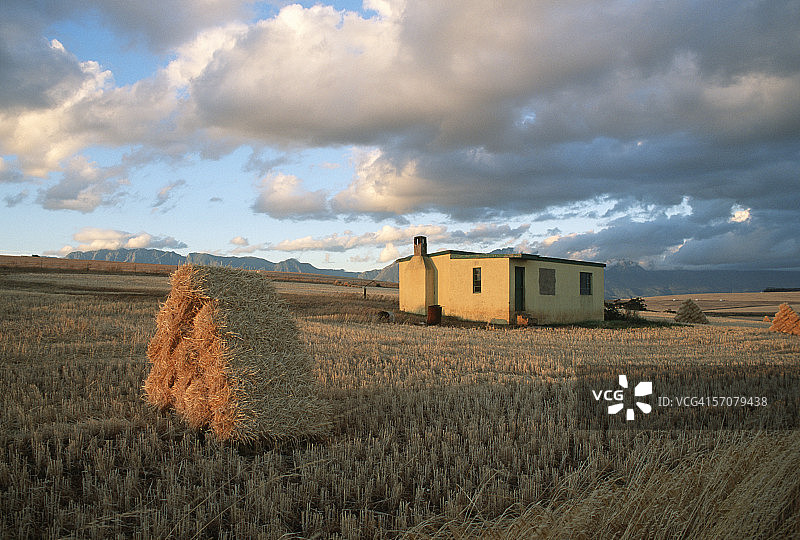 风景优美的农舍和前景中的干草捆图片素材
