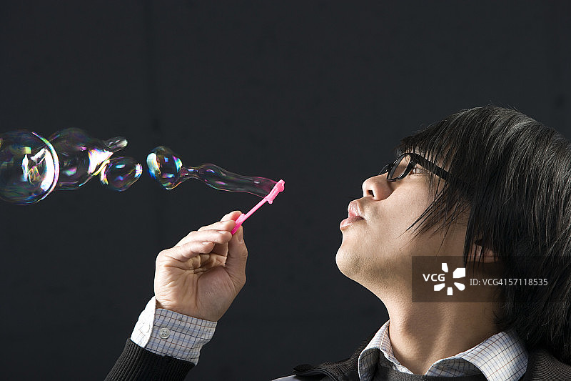 中年男人用泡泡棒吹泡泡特写图片素材