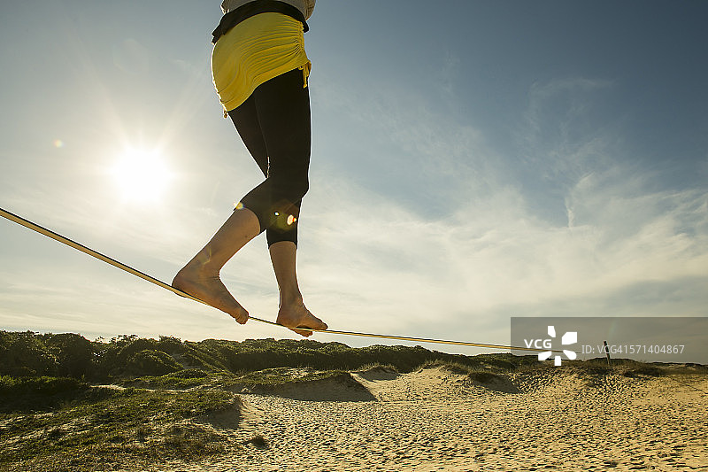 女人在白色沙滩上走软绳图片素材