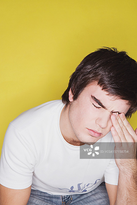 揉眼睛的年轻男人图片素材
