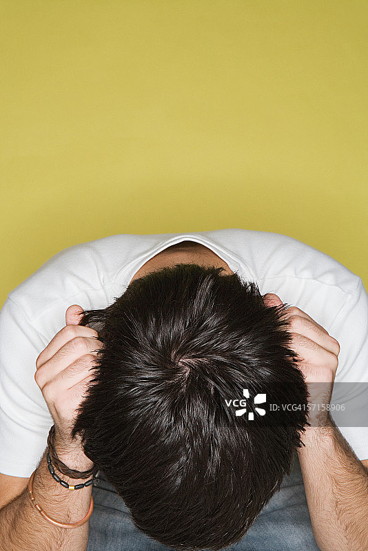 双手抱头的年轻男人图片素材