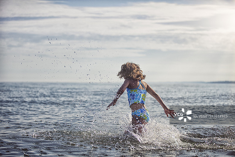 女孩跑入水中激起大水花图片素材