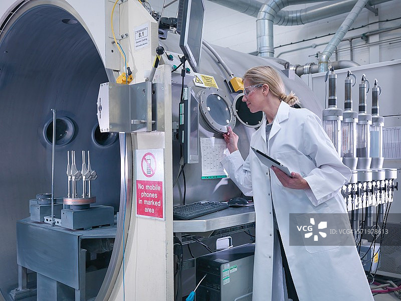 在骨科工厂使用陶瓷涂层机为人工髋关节涂层的女工程师图片素材
