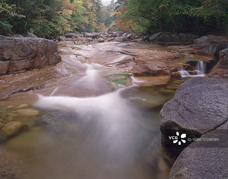 秋雨过后，汉考克溪北叉的流水冲刷着岩石，位于新罕布什尔州白山国家森林公园的卡卡马古斯高速公路旁图片素材