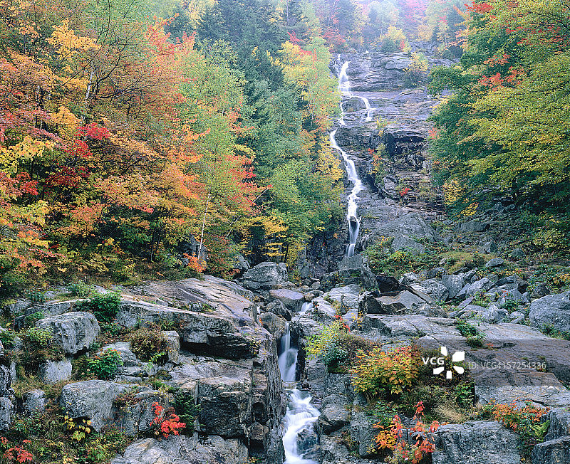 秋色树木环绕下的银色瀑布薄雾，新罕布什尔州克劳福德峡谷州立公园图片素材