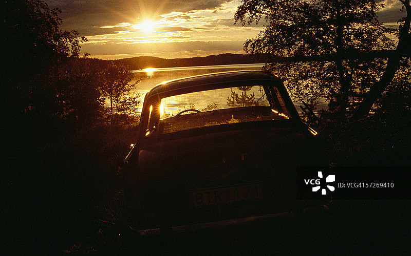 夕阳下湖边的老汽车图片素材