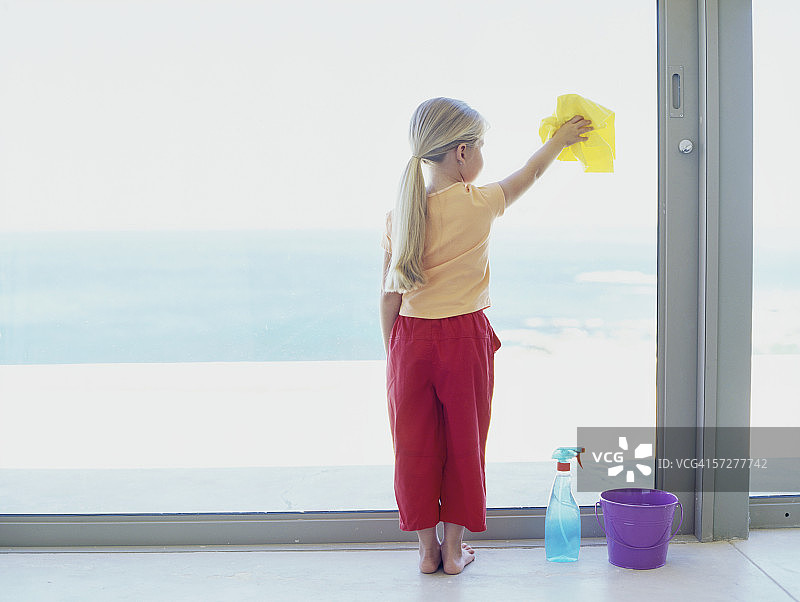 女孩清洁窗户的背影图片素材