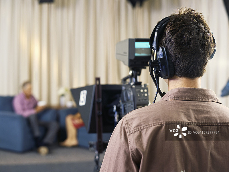在电视演播室工作的年轻摄影师的背影图片素材