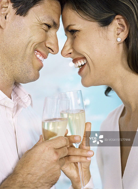 一对中年夫妇举着香槟酒杯敬酒的侧面照图片素材