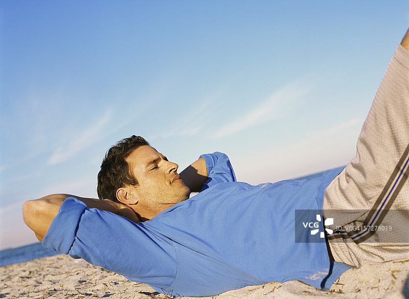 中年男人在海滩上锻炼的侧面照图片素材