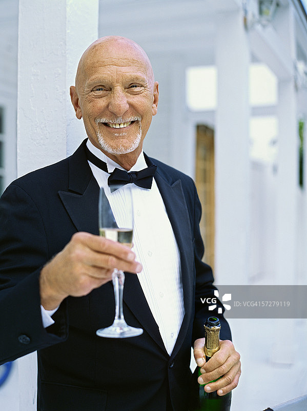 手持香槟酒杯的年长男人肖像图片素材