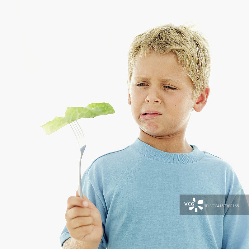 拿着生菜叶和叉子的男孩图片素材