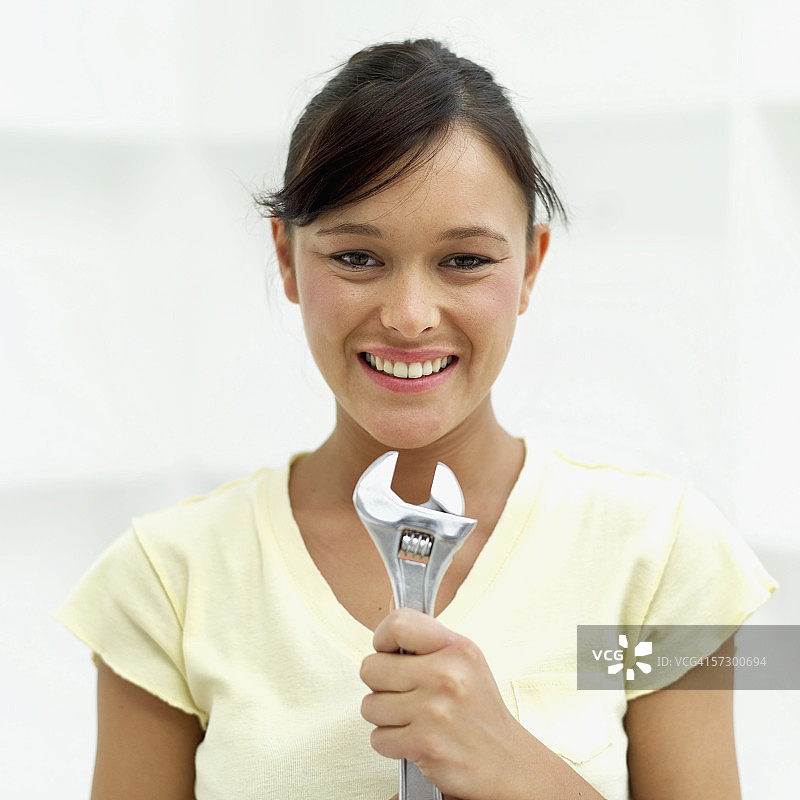 年轻女人拿着扳手的特写镜头图片素材