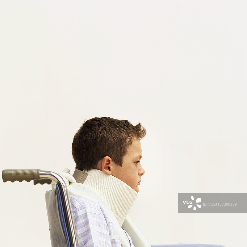 坐轮椅戴颈托的小男孩特写图片素材