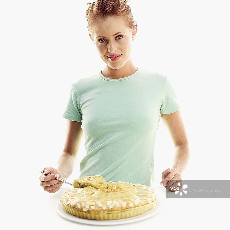 年轻女性用馅饼刀拿起一块馅饼的肖像图片素材