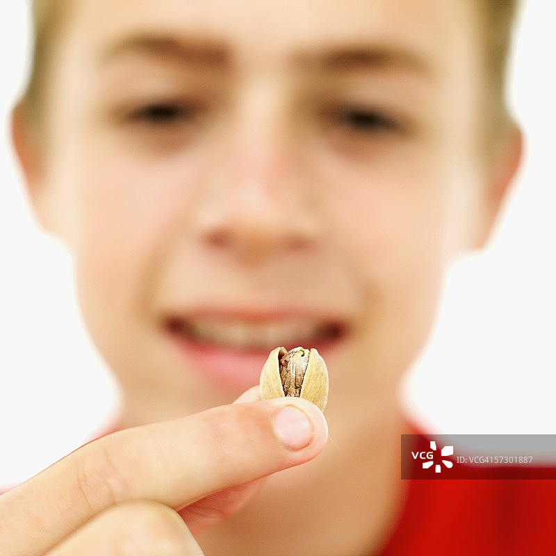 少年手中拿着开心果的特写图片素材