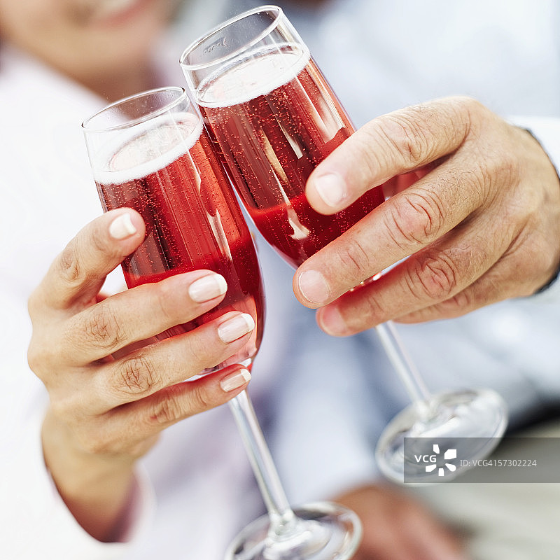 一对老年夫妇的手拿着酒杯的特写图片素材
