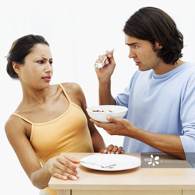 年轻男子从碗里给女子喂食图片素材