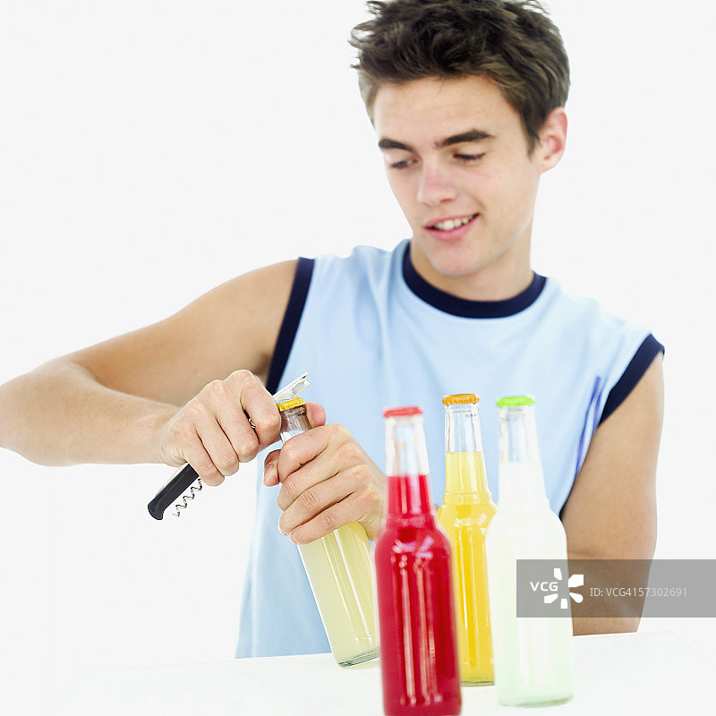 打开一瓶混合酒精饮料的少年图片素材