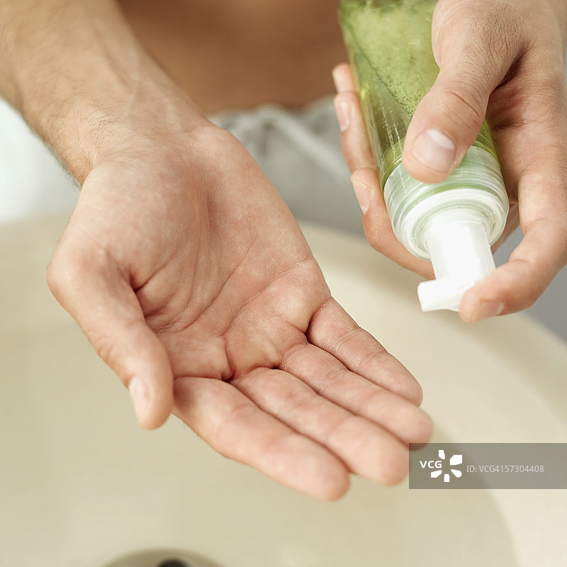 年轻男子拿着须后水的特写图片素材